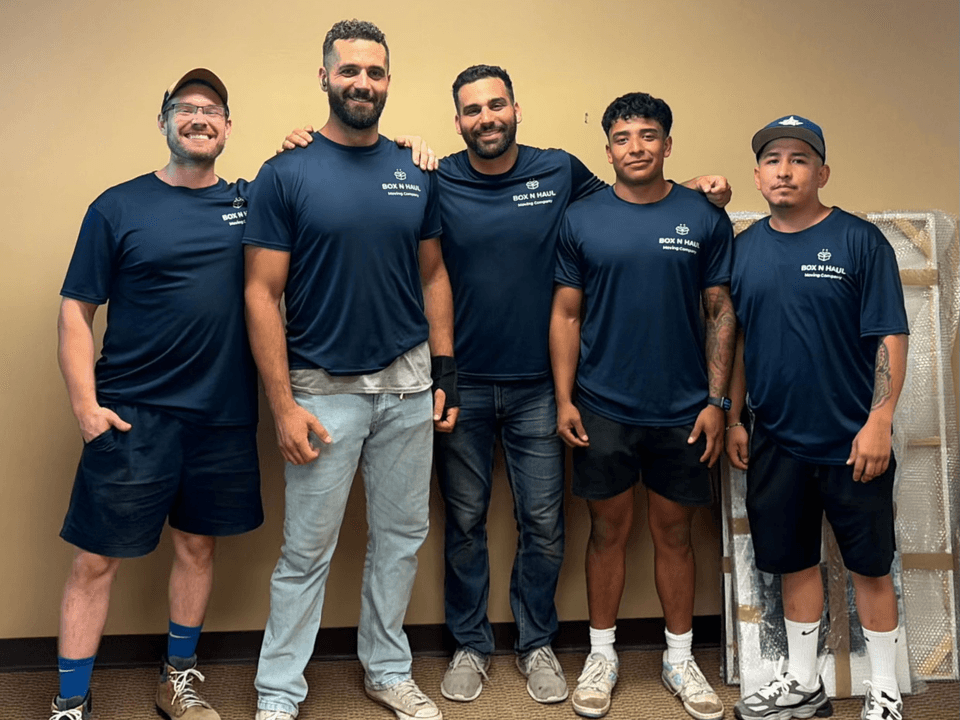 The Box N Haul moving crew in branded navy shirts standing together during a commercial office move