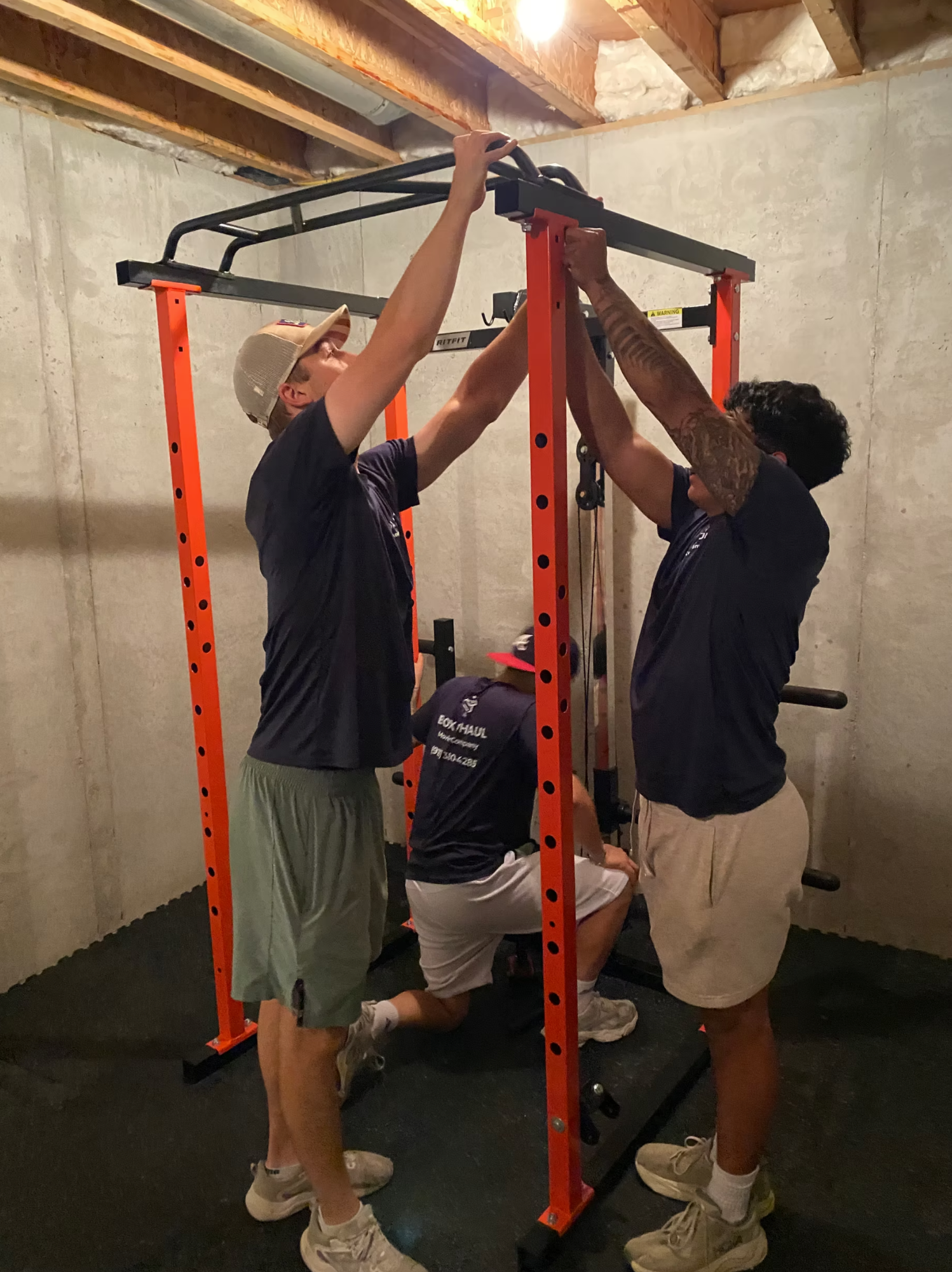 Box N Haul crew assembling a home gym power rack.