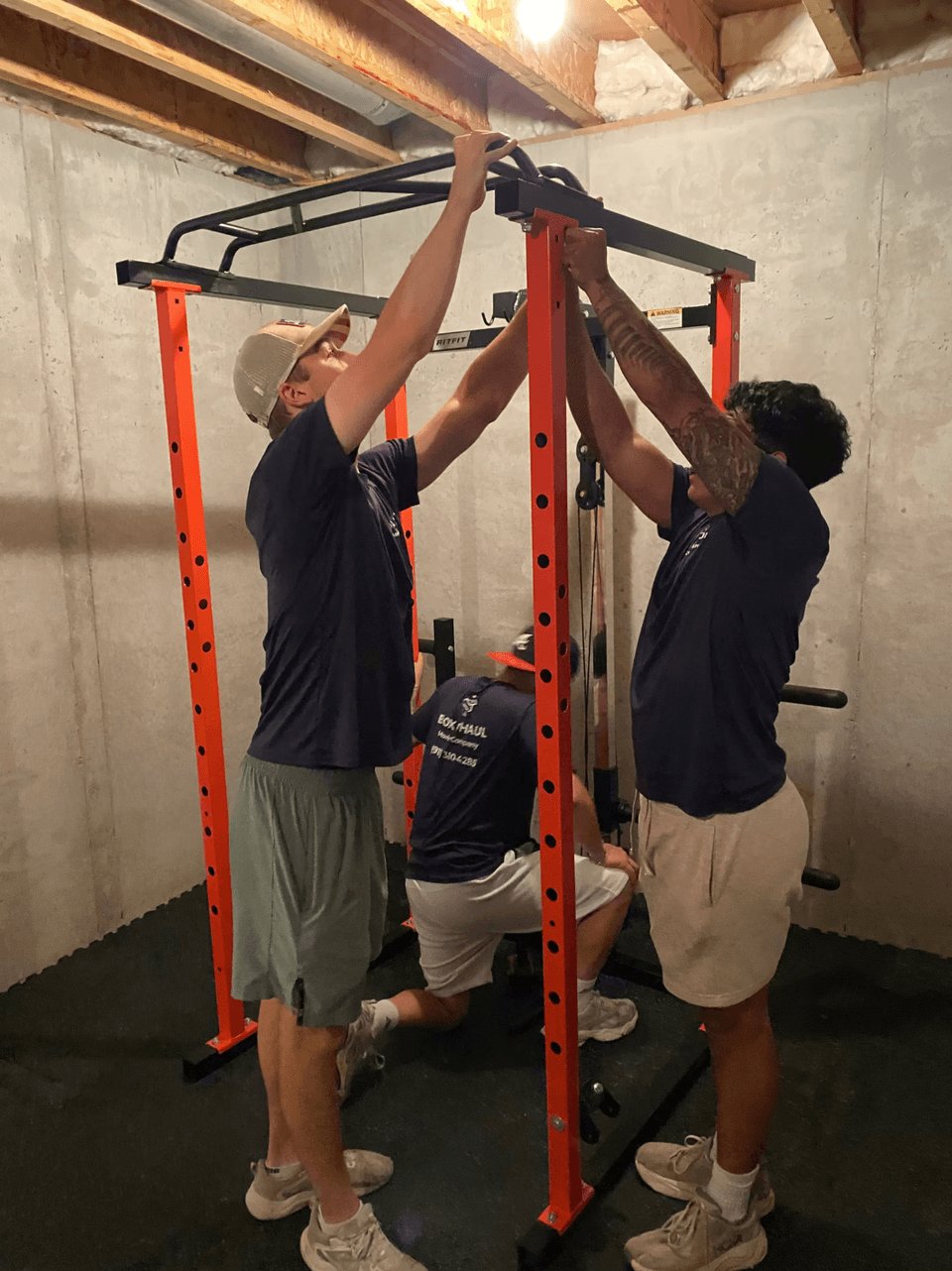 Box N Haul crew working on assembly of a home gym power rack